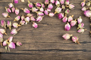 Ahşap zemine saçılmış kurumuş tomurcuk gülleri yığını. Yüksek kalite fotoğraf
