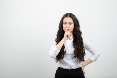 Ayakta duran ve sessiz bir jest yapan güzel bir kadının portresi. Yüksek kalite fotoğraf