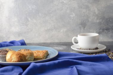 White cup of hot black tea with sweet snacks placed on stone table. High quality photo