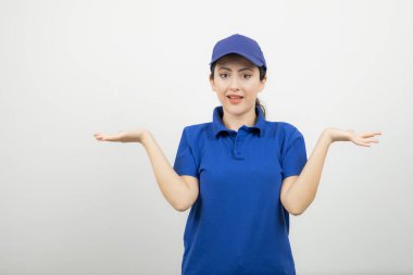 Mavi şapkalı genç bayan kuryenin portresi duruyor ve poz veriyor. Yüksek kalite fotoğraf