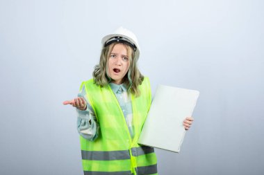 Elinde boş tuval tutan ve bir şeye şaşıran güzel bir kadın sanayi işçisi. Yüksek kalite fotoğraf