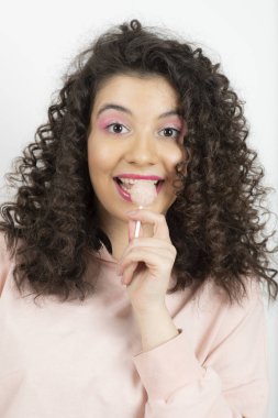 Yeşil lolipop yiyen kıvırcık esmer kadının portresi. Yüksek kalite fotoğraf