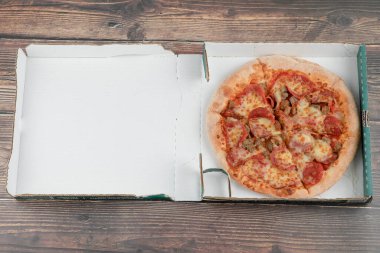 Karton kutuda salam ve etle karışık lezzetli pizza. Yüksek kalite fotoğraf