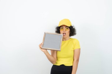 Beyaz arka planda poz veren pankartlı genç kadın. 