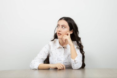 Masada oturan ve yan bakan hayalperest iş kadını. Yüksek kalite fotoğraf