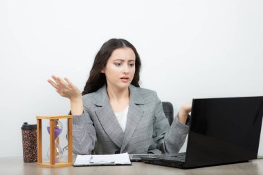 Esmer ofis çalışanı iş yerinde dizüstü bilgisayarı ve kahvesiyle oturuyor. Yüksek kalite fotoğraf