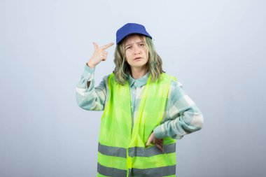 Beyaz duvarın üzerinde duran üniformalı kadın mimarın portresi. Yüksek kalite fotoğraf