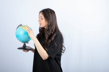 Uzun saçlı esmer kadın dünya üzerinde seyahat etmek için bir yer seçiyor. Yüksek kalite fotoğraf