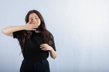 Beautiful brunette girl wearing black medical mask and scratching her face. High quality photo