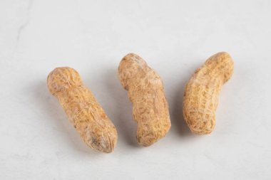 Beyaz arka planda soyulmamış üç fıstık. Yüksek kalite fotoğraf