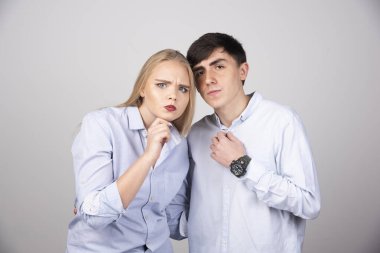 Gri arka planda kameraya poz veren genç bir çiftin portresi. Yüksek kalite fotoğraf