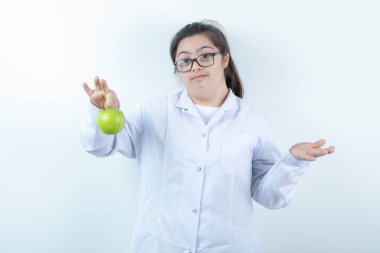 Elinde yeşil elma tutan doktor üniformalı genç bir kız. Yüksek kalite fotoğraf