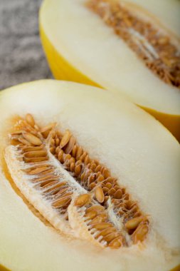 Taş zemine yarım dilimlenmiş sarı kavun yerleştirilmiş. Yüksek kalite fotoğraf