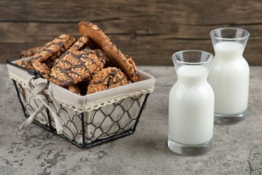 Sepetinde çikolata jöleli leziz çoklu tahıllı kurabiyeler ve iki bardak süt kavanozu. Yüksek kalite fotoğraf