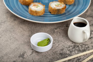 Wasabi ve soya soslu suşi ruloları bir taş masaya konur. Yüksek kalite fotoğraf