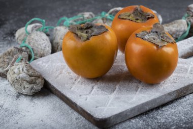 Siyah yüzeyde taze hurma ağaçları etrafında şeker tozu ile kurutulmuş hurma. Yüksek kalite fotoğraf