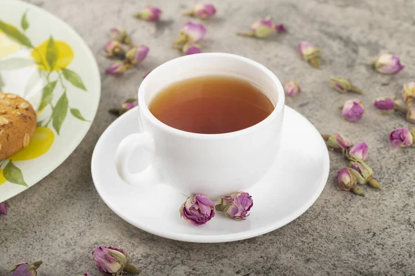 クッキーと乾燥バラの芽と熱いお茶の白いカップ 高品質の写真 — ストック写真