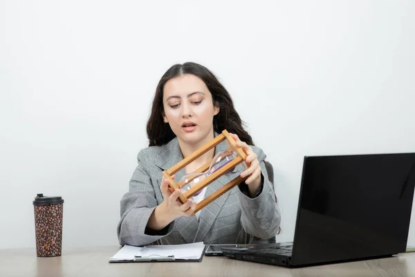 Brünette Büroangestellte Sitzt Arbeitsplatz Und Hält Sanduhr Hochwertiges Foto — Stockfoto