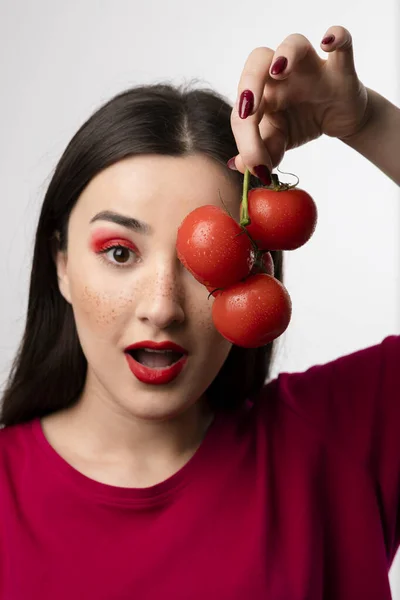 Piękna Dziewczyna Trzymająca Przed Oczami Kilka Czerwonych Pomidorów Wysokiej Jakości — Zdjęcie stockowe