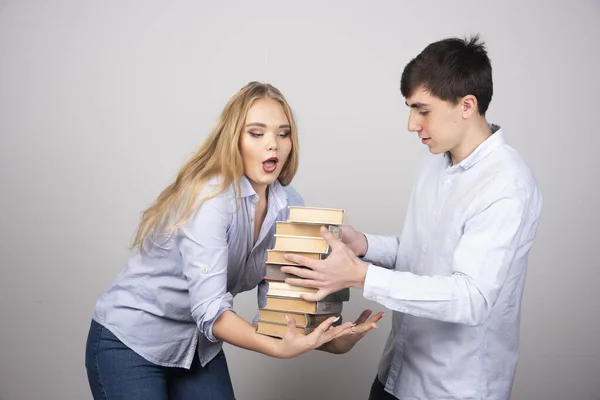 Giovane Mucchio Libri Suo Partner Sfondo Grigio Foto Alta Qualità — Foto Stock