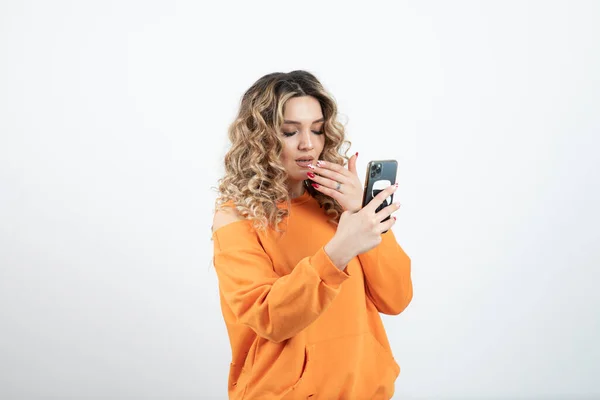 Młoda Kobieta Falowanymi Włosami Używająca Smartfona Wysokiej Jakości Zdjęcie — Zdjęcie stockowe