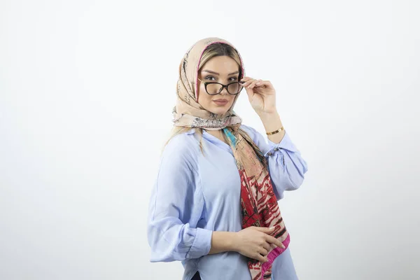 Image of blonde young woman in handkerchief wearing glasses . High quality photo