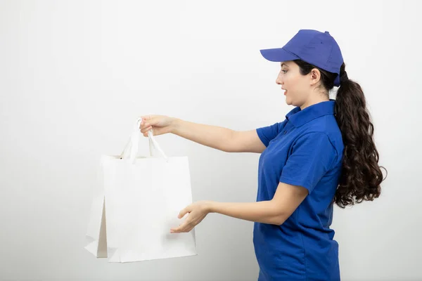 Hermosa Mensajera Femenina Traje Azul Mostrando Bolsas Blancas Foto Alta —  Fotos de Stock