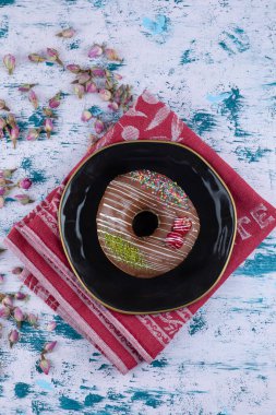 Çikolatalı çörek ve beyaz masada tomurcuklanan güller. Yüksek kalite fotoğraf