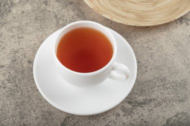 White cup of hot black tea on stone surface. High quality photo