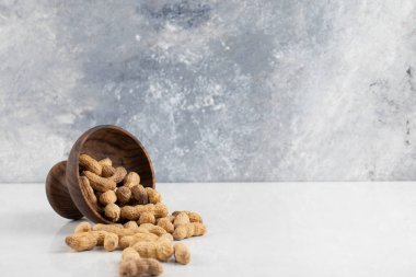 Beyaz arka planda izole edilmiş tahta kasede kabuklu sağlıklı fıstıklar. Yüksek kalite fotoğraf