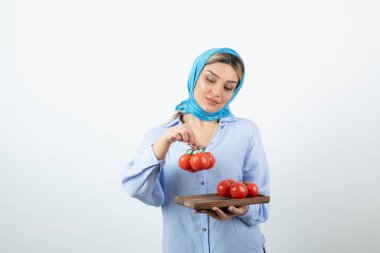 Elinde ahşap domates tahtası olan mendilli güzel bir kadın resmi. Yüksek kalite fotoğraf