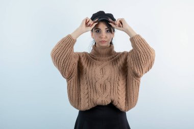 Beyaz duvarda örgü giysili güzel bir kadın resmi. Yüksek kalite fotoğraf