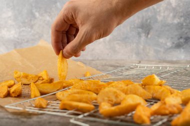 Erkek el, patates dilimini taş masadan alıyor. Yüksek kalite fotoğraf