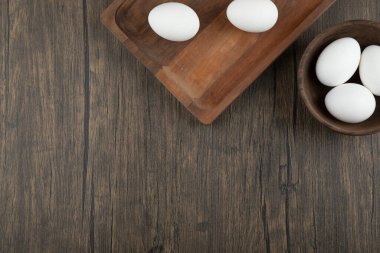 Tahta tahta tahta ve ahşap arka planda organik çiğ yumurta dolu bir kase. Yüksek kalite fotoğraf