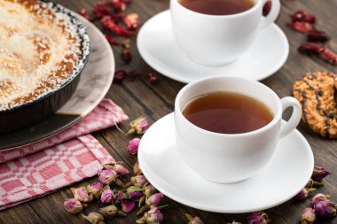 Hindistan cevizi parçalı bir tabak tatlı turta, bisküvi ve ahşap zemin üzerinde bir fincan çay. Yüksek kalite fotoğraf