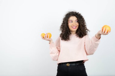 Güzel kıvırcık kız elinde taze portakal meyveleri tutuyor. Yüksek kalite fotoğraf