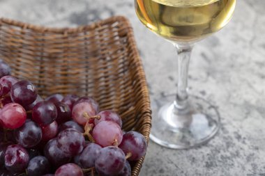 Bir kadeh beyaz şarap ve arka planda taze kırmızı üzümler. Yüksek kalite fotoğraf