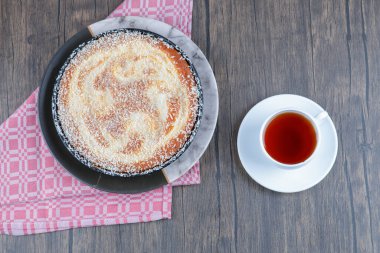 Tahta masaya bir fincan siyah çay ile bir tabak lezzetli turta. Yüksek kalite fotoğraf