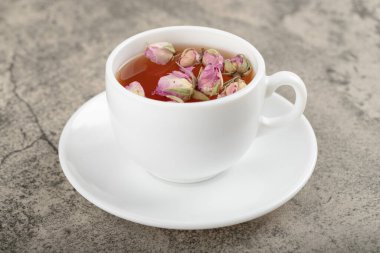 Taş yüzeyinde kurumuş güller olan bir fincan siyah çay. Yüksek kalite fotoğraf