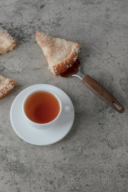 Lezzetli tatlı bir parça ve mermer zemin üzerinde bir fincan çay. Yüksek kalite fotoğraf