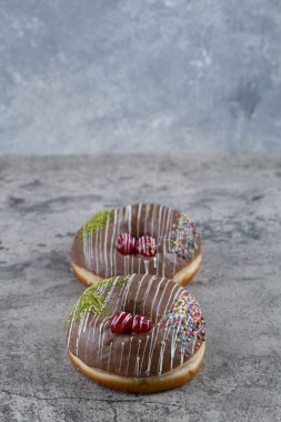 Mermer yüzeyde iki lezzetli çikolata parçacıklı çörek. Yüksek kalite fotoğraf