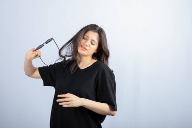 Beyaz arka planda güneş gözlüğüyle poz veren şık bir genç kadın. - Evet. Yüksek kalite fotoğraf