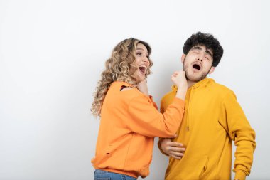 Genç dalgalı saçlı kadın esmer adama yumruk atıyor. Yüksek kalite fotoğraf