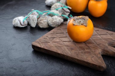 Siyah yüzeyde taze hurma ağaçları etrafında şeker tozu ile kuru hurma. Yüksek kalite fotoğraf