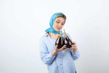 Mendilli, patlıcan tutan sarışın güzel bir kadın resmi. Yüksek kalite fotoğraf