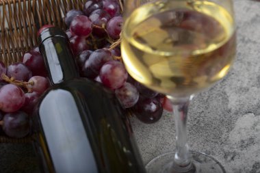 Kırmızı üzümlü hasır sepet ve arka planda beyaz şarap. Yüksek kalite fotoğraf