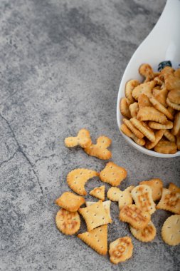 Beyaz kaşık dolusu çıtır kraker taştan bir arka plana yerleştirilmiş. Yüksek kalite fotoğraf