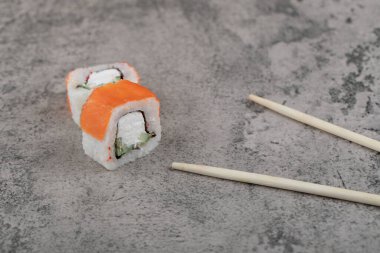 Geleneksel Philadelphia suşisi, taş yüzeyinde somon balığı ile yuvarlanır. Yüksek kalite fotoğraf