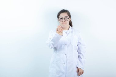 Doktor üniformalı genç bir bayan dur işareti yapıyor. Yüksek kalite fotoğraf