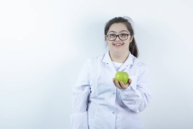 Elinde yeşil elma tutan doktor üniformalı genç bir kız. Yüksek kalite fotoğraf
